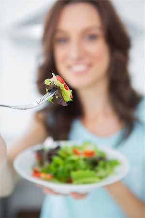 simsearch:400-06932687,k - Healthy brunette in her kitchen offering salad to the camera Stock Photo - Budget Royalty-Free & Subscription, Code: 400-06932687