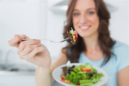 simsearch:400-06932687,k - Brunette in her kitchen offering healthy salad to the camera Stock Photo - Budget Royalty-Free & Subscription, Code: 400-06932688