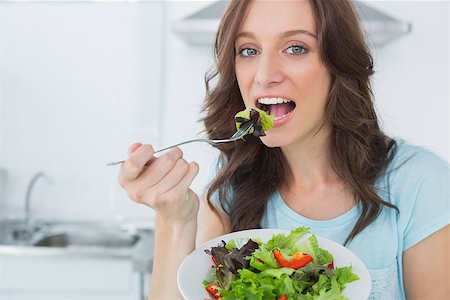 simsearch:400-06932687,k - Brunette eating healthy salad in her kitchen Stock Photo - Budget Royalty-Free & Subscription, Code: 400-06932689