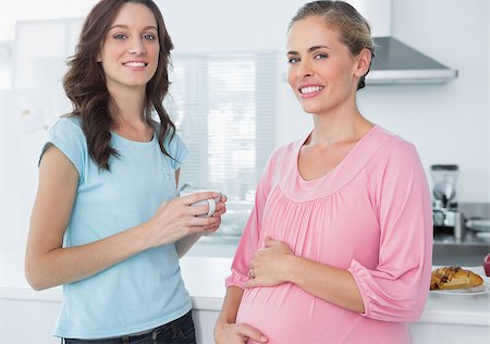 Happy pregnant woman and her friend posing in the kitchen Stock Photo - Budget Royalty-Free & Subscription, Code: 400-06932694