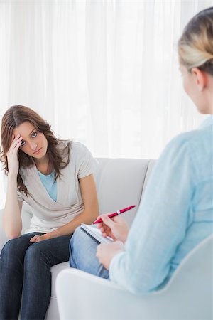 simsearch:400-06932773,k - Worried woman sitting with therapist taking notes on couch in office Stock Photo - Budget Royalty-Free & Subscription, Code: 400-06932735