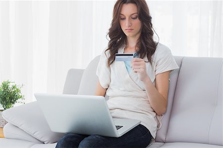 simsearch:400-07474252,k - Woman shopping online with her laptop and sitting on the couch Stock Photo - Budget Royalty-Free & Subscription, Code: 400-06932759