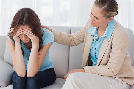 simsearch:400-07273405,k - Worried woman being comforted by her therapist and sitting on the couch Fotografie stock - Microstock e Abbonamento, Codice: 400-06932767