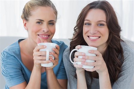 simsearch:400-07059986,k - Friends having coffee and looking at camera sitting on the couch Stock Photo - Budget Royalty-Free & Subscription, Code: 400-06932850