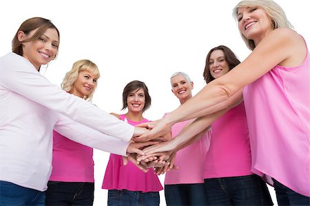 simsearch:400-06932882,k - Women posing in circle holding hands wearing pink for breast cancer looking at camera on white background Stock Photo - Budget Royalty-Free & Subscription, Code: 400-06932879