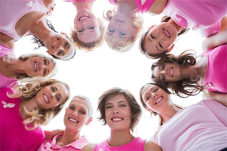 simsearch:400-06932887,k - Group of happy women in circle wearing pink for breast cancer on white background Fotografie stock - Microstock e Abbonamento, Codice: 400-06932897