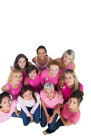 simsearch:400-06932887,k - Cheerful pretty women looking up wearing pink for breast cancer on white background Fotografie stock - Microstock e Abbonamento, Codice: 400-06932899