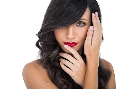 Glamorous brunette posing finger on her red lips on white background Foto de stock - Super Valor sin royalties y Suscripción, Código: 400-06933224