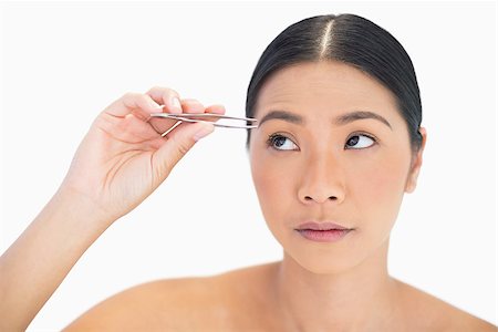 simsearch:6108-06905650,k - Thinking natural model using tweezers for her eyebrow on white background Stock Photo - Budget Royalty-Free & Subscription, Code: 400-06933544