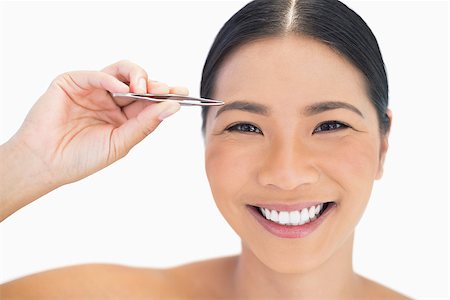 simsearch:614-03649482,k - Cheerful natural woman using tweezers for her eyebrow on white background Photographie de stock - Aubaine LD & Abonnement, Code: 400-06933547