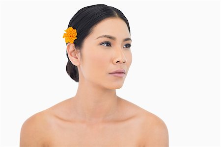 simsearch:6108-06905650,k - Pensive dark haired model with flower in hair on white background Stock Photo - Budget Royalty-Free & Subscription, Code: 400-06933718