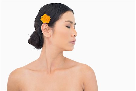 simsearch:6108-06905650,k - Pensive dark haired model with orange flower in hair on white background Stock Photo - Budget Royalty-Free & Subscription, Code: 400-06933720