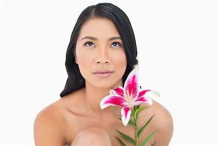 simsearch:6108-06905650,k - Pensive natural black haired model posing with lily on white background Stock Photo - Budget Royalty-Free & Subscription, Code: 400-06933750