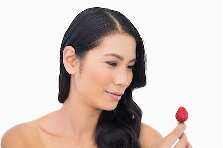 simsearch:693-06021794,k - Happy gorgeous brown haired model with strawberry on white background Stock Photo - Budget Royalty-Free & Subscription, Code: 400-06933774