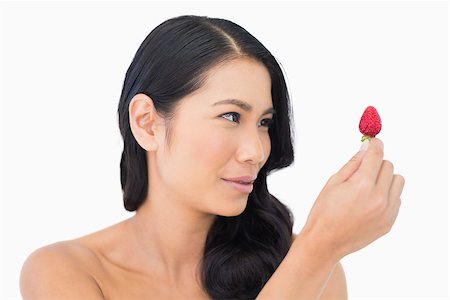 simsearch:693-06021794,k - Gorgeous brown haired model holding strawberry on white background Stock Photo - Budget Royalty-Free & Subscription, Code: 400-06933775