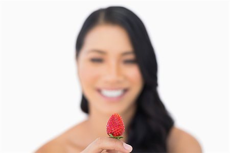 simsearch:693-06021794,k - Attractive brown haired model holding strawberry on white background Stock Photo - Budget Royalty-Free & Subscription, Code: 400-06933777