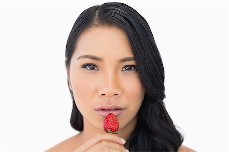 simsearch:693-06021794,k - Attractive brown haired model with strawberry on white background Stock Photo - Budget Royalty-Free & Subscription, Code: 400-06933778