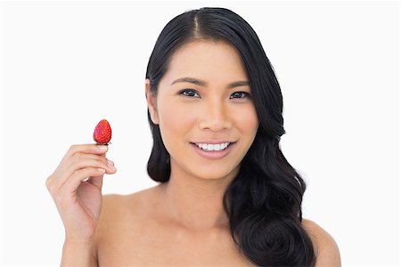 simsearch:693-06021794,k - Cheerful natural brown haired model with strawberry on white background Stock Photo - Budget Royalty-Free & Subscription, Code: 400-06933772