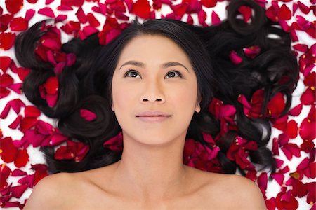 simsearch:6108-06905650,k - Pensive sensual dark haired model lying in rose petals on white background Stock Photo - Budget Royalty-Free & Subscription, Code: 400-06933786