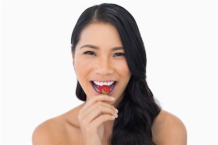 simsearch:693-06021794,k - Smiling attractive brown haired model eating strawberry on white background Stock Photo - Budget Royalty-Free & Subscription, Code: 400-06933780