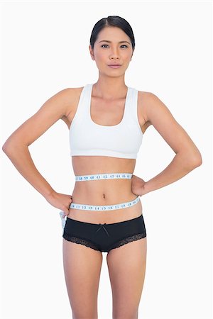 simsearch:400-04955629,k - Self confident slim woman measuring her waist on white background Stock Photo - Budget Royalty-Free & Subscription, Code: 400-06933826