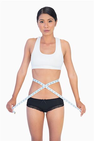 simsearch:400-04955629,k - Serious slim woman measuring her waist on white background Stock Photo - Budget Royalty-Free & Subscription, Code: 400-06933828