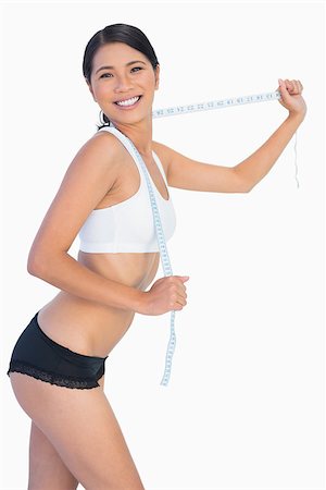 simsearch:400-04955629,k - Smiling slim woman playing with her measuring tape on white background Stock Photo - Budget Royalty-Free & Subscription, Code: 400-06933833