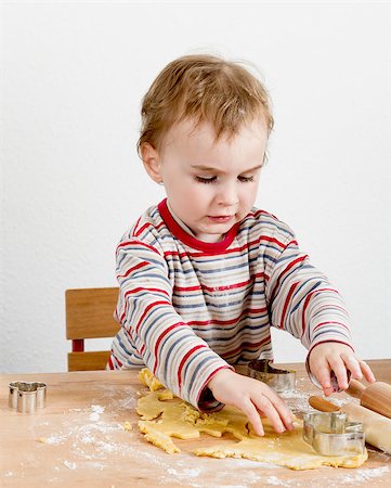child at wooden desk making cookies. vertical image Foto de stock - Royalty-Free Super Valor e Assinatura, Número: 400-06946990