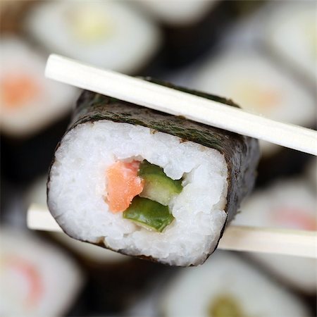 Fresh Japanese Sushi with fish and rice on chopsticks Stock Photo - Budget Royalty-Free & Subscription, Code: 400-06947001