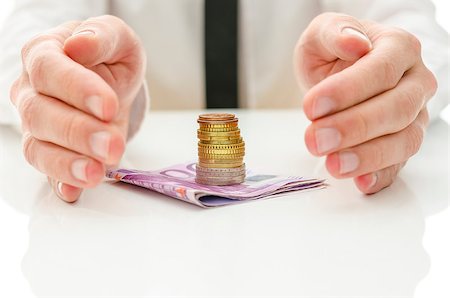 simsearch:400-06860365,k - Male hands around stack of Euro coins on banknotes on a white desk. Financial concept. Stock Photo - Budget Royalty-Free & Subscription, Code: 400-06947279