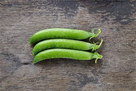 pod peas - fresh pea pods in a row, on wood table Stock Photo - Budget Royalty-Free & Subscription, Code: 400-06948422