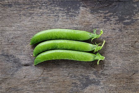 sweet pea - fresh pea pods in a row, on wood table Stock Photo - Budget Royalty-Free & Subscription, Code: 400-06948422