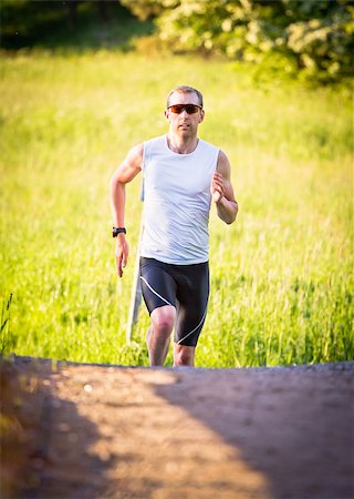 simsearch:400-07509642,k - A man runs up a hill in sunset Stock Photo - Budget Royalty-Free & Subscription, Code: 400-06948798