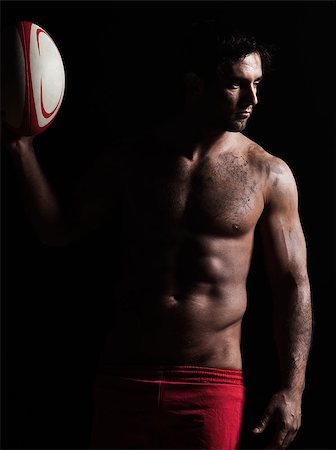 one caucasian sexy topless man portrait holding  a rugby ball on studio black background Stock Photo - Budget Royalty-Free & Subscription, Code: 400-06948940