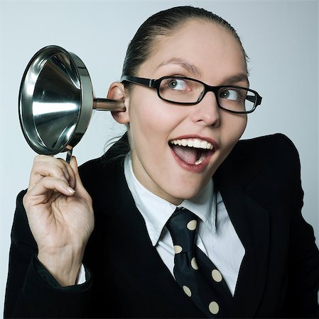 studio shot portrait of one caucasian curious business woman  hearing aid funnel curious spying gossip Stock Photo - Budget Royalty-Free & Subscription, Code: 400-06948976