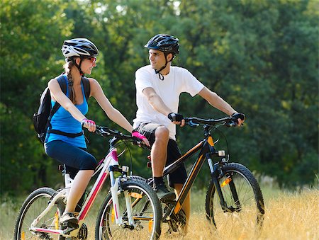 Young Happy Couple Riding Mountain Bikes Outdoor. Healthy Lifestile Concept Foto de stock - Royalty-Free Super Valor e Assinatura, Número: 400-06954104