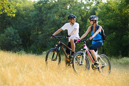 Young Happy Couple Riding Mountain Bikes Outdoor. Healthy Lifestile Concept Photographie de stock - Aubaine LD & Abonnement, Code: 400-06954103