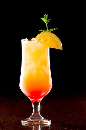 simsearch:400-06797125,k - tequila sunrise, fresh orange juice with tequila and cherry juice served in a stem glass on a dark bar Stock Photo - Budget Royalty-Free & Subscription, Code: 400-06954152