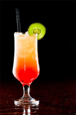 simsearch:400-06797125,k - sex on the beach, fresh orange juice with vodka and cherry juice served in a stem glass on a dark bar Stock Photo - Budget Royalty-Free & Subscription, Code: 400-06954153
