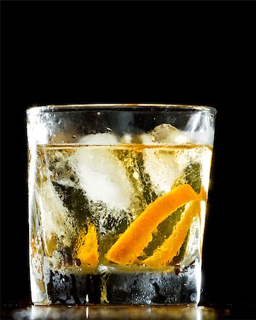 simsearch:400-06797125,k - whiskey served on ice garnished with an orange twist served on a wooden bar Stock Photo - Budget Royalty-Free & Subscription, Code: 400-06954624