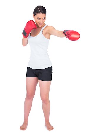 Smiling slender model with boxing gloves punching while posing on white background Stock Photo - Budget Royalty-Free & Subscription, Code: 400-06954953