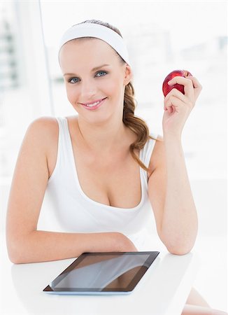simsearch:685-02937448,k - Cheerful pretty sportswoman holding an apple in a bright room Stock Photo - Budget Royalty-Free & Subscription, Code: 400-06955819