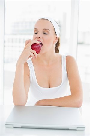 simsearch:685-02937448,k - Calm pretty sportswoman eating an apple in a bright room Stock Photo - Budget Royalty-Free & Subscription, Code: 400-06955811