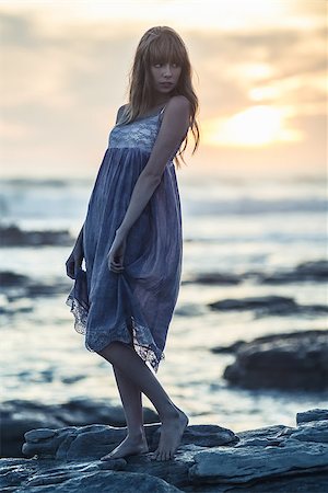 simsearch:400-06956665,k - Beautiful model posing on rocks by the sea looking away at sunset Stockbilder - Microstock & Abonnement, Bildnummer: 400-06955935