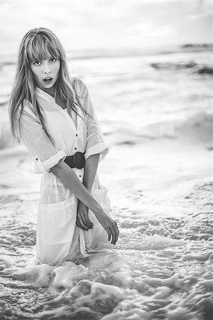 simsearch:6109-08690486,k - Beautiful model in shirt dress standing in the sea in black and white artistic shot Foto de stock - Super Valor sin royalties y Suscripción, Código: 400-06955938