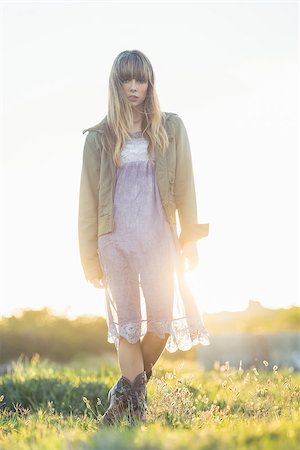 Fashionable young girl in sheer dress and jacket staring at camera in the countryside Stock Photo - Budget Royalty-Free & Subscription, Code: 400-06955930