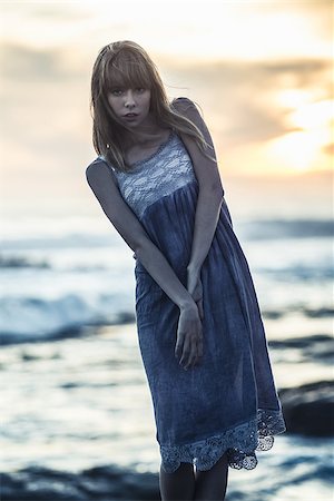 simsearch:400-06956665,k - Beautiful young model standing on rocks by the sea on a glowing background Stockbilder - Microstock & Abonnement, Bildnummer: 400-06955932