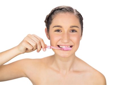 Smiling young model on white background brushing her teeth Foto de stock - Super Valor sin royalties y Suscripción, Código: 400-06956498