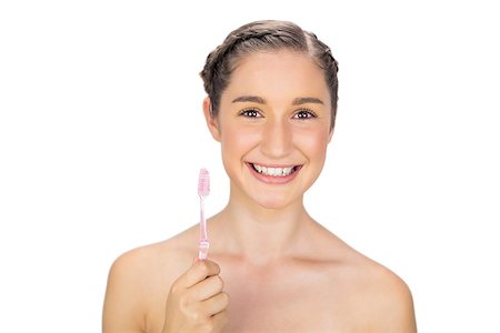 Cheerful young model on white background holding toothbrush Photographie de stock - Aubaine LD & Abonnement, Code: 400-06956500