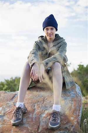 simsearch:400-06956627,k - Woman wearing cap sitting on stone looking at camera Stock Photo - Budget Royalty-Free & Subscription, Code: 400-06956524